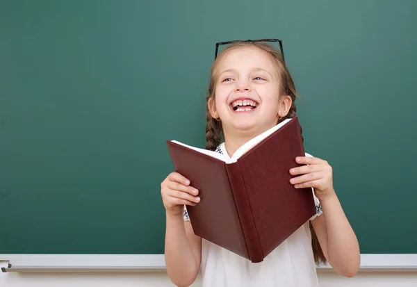 Scuola ragazza leggere libro, posa al consiglio scolastico, spazio vuoto, concetto di istruzione — Foto Stock