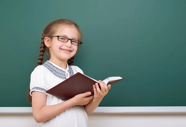 Dziewczyna w szkole czytać książki, pozowanie w kuratorium, pustej przestrzeni, koncepcja edukacji — Zdjęcie stockowe
