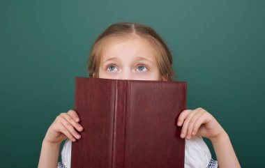 Liseli kız poz okul yönetimi, boş alanı, eğitim kavramı kitap okumak