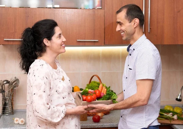 夫妇在厨房内饰带箱的新鲜水果和蔬菜，健康食品的概念，怀孕的女人和男人 — 图库照片
