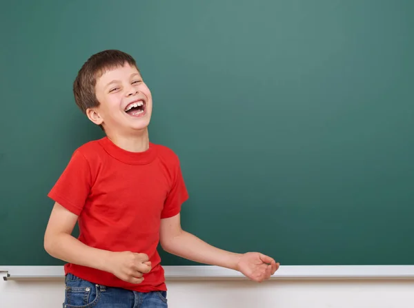 Skolpojke spela och skratta nära en blackboard, tomt utrymme, utbildning koncept — Stockfoto