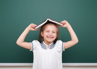 Kitap yakınındaki bir yazı tahtası, boş alanı, eğitim kavramı ile kız öğrenci