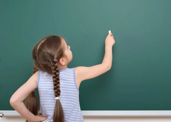 Schülerin schreibt Kreide an Tafel, leerer Raum, Bildungskonzept — Stockfoto