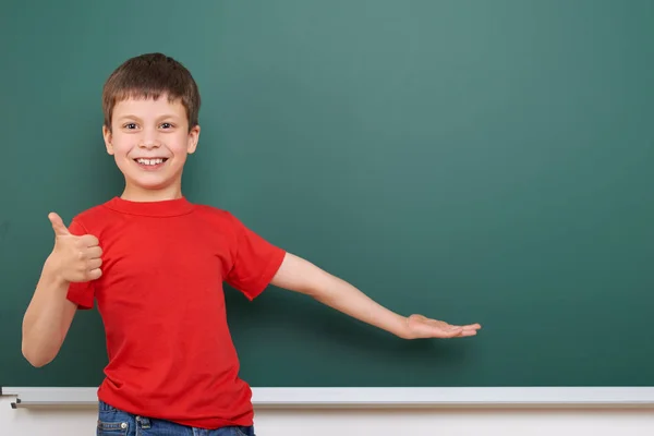 Skolpojke spela nära en blackboard, tomt utrymme, utbildning koncept — Stockfoto