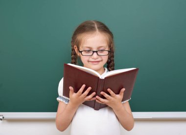 Liseli kız poz okul yönetimi, boş alanı, eğitim kavramı kitap okumak