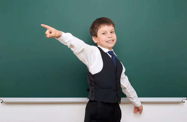 Schüler posiert vor der Schultafel, leerer Raum, Bildungskonzept — Stockfoto