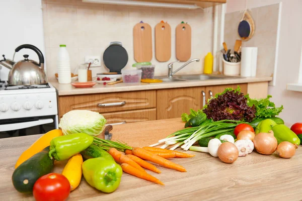 Friss gyümölcs és zöldség az asztalon a konyha belsejében, egészséges étel koncepció — Stock Fotó