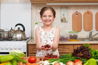 avuç kiraz, meyve ve sebze ev mutfak iç, sağlıklı gıda konsepti ile poz kız çocuk