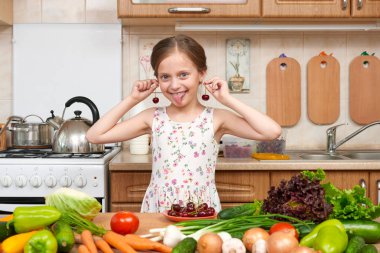 çocuk kız oyun ve sahip eğlenceli kiraz, meyve ve sebze ev mutfak iç, sağlıklı gıda kavramı ile