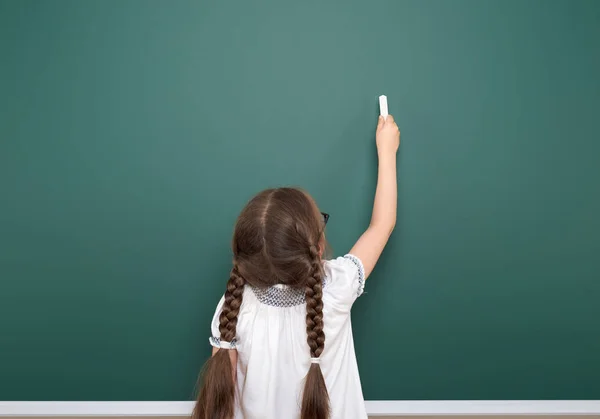 Schoolgirl writing chalk on a blackboard, empty space, education concept — Stock Photo, Image