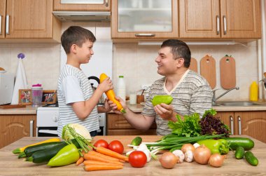 Baba ve oğul ev mutfak interi sebze ile eğleniyor