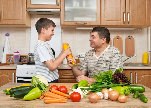 Baba ve oğul ev mutfak interi sebze ile eğleniyor