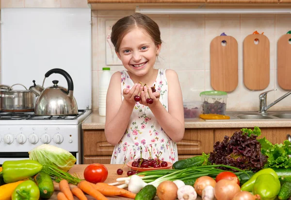 Kind meisje poseren met handvol kersen, fruit en groente — Stockfoto