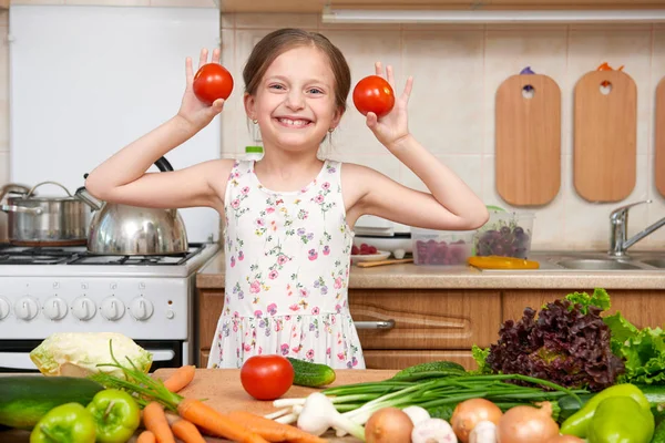 Kind meisje met plezier met tomaten. Huis keuken interieur met — Stockfoto