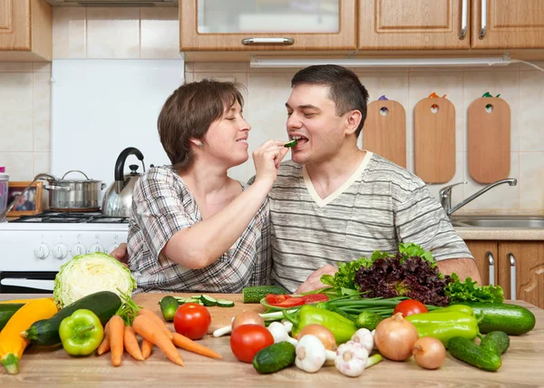 Couple cooking in kitchen interior with fresh fruits and vegetables, healthy food concept, woman and man — Stock Photo, Image