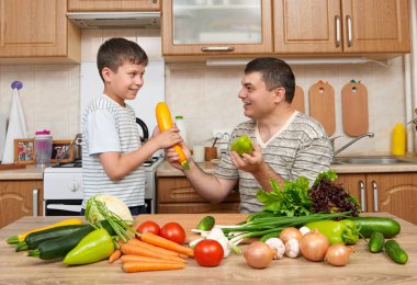 Baba ve oğul ev mutfak interi sebze ile eğleniyor