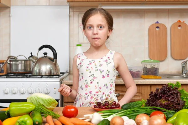 Criança menina comer cerejas, frutas e legumes em casa cozinha i — Fotografia de Stock