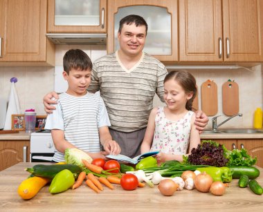 Baba ve iki çocuk yemek kitabı ve seçim yemekleri okuma. 