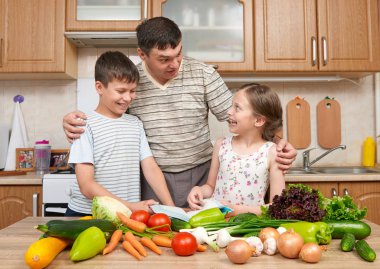 Baba ve iki çocuk yemek kitabı ve seçim yemekleri okuma. 