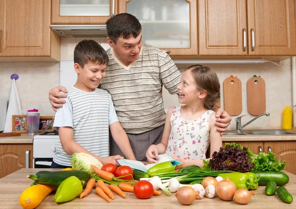 Baba ve iki çocuk yemek kitabı ve seçim yemekleri okuma. 