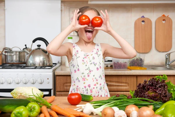 Enfant fille s'amuser avec des tomates. Accueil cuisine intérieur avec — Photo