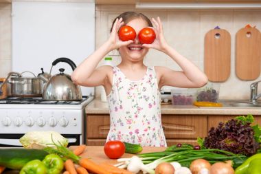 Domates ile eğleniyor kız çocuk. Ev mutfak iç ile 