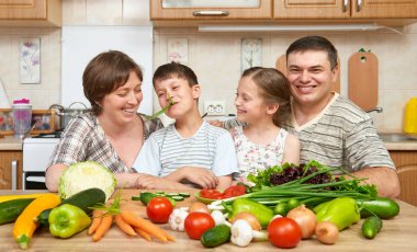 mutfak iç evde, taze meyve ve sebze, sağlıklı gıda kavramı, kadın, erkek ve pişirme ve having fun çocuk aile portresi