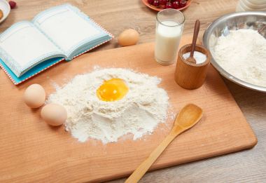 Un yığın ve ahşap bir arka plan üzerinde pişirme için kırık yumurta portre. Çiğ gıda ve mutfak gereçleri.