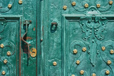 Old iron door, forged and painted in green color with golden flowers for background, vintage style, retro elements clipart