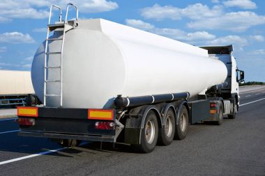 Petrol kamyon boş sarnıç ve bulutlu gökyüzü, kargo taşıma kavramı ile yolda
