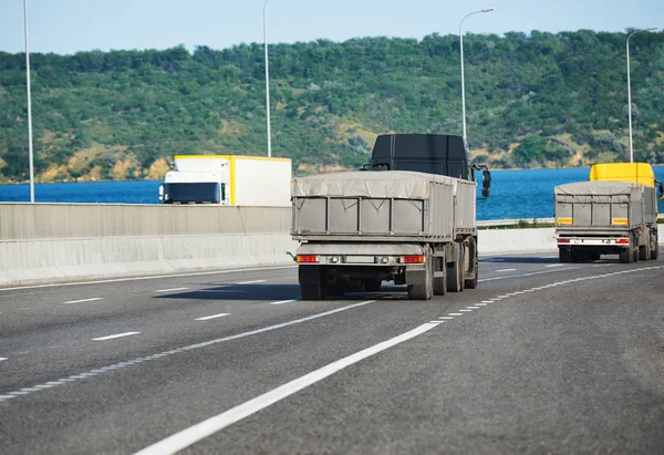 Lastbilar med gods på motorvägen, frakt och transport koncept — Stockfoto