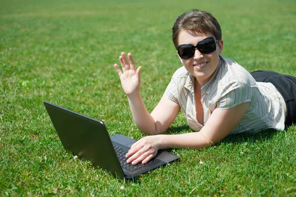 İçinde laptop üzerinde çalışan kadın açık yaz, tebrik jest, mutlu insanlar, Şehir Parkı yeşil çim çayır, yat yalan