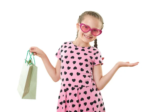 Красивая маленькая девочка с сумкой для покупок, студийный портрет, одетый в розовый с форме сердца, белый фон — стоковое фото