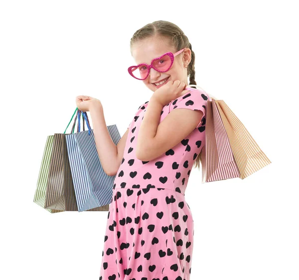 Pretty little girl with shopping bag, studio portrait, dressed in pink with heart shapes, white background — Stock Photo, Image