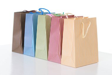 üst üste nesne üzerinde beyaz izole düzenlenmiş renkli çizgili alışveriş torbaları