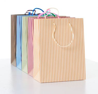 üst üste nesne üzerinde beyaz izole düzenlenmiş renkli çizgili alışveriş torbaları