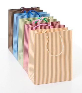 üst üste nesne üzerinde beyaz izole düzenlenmiş renkli çizgili alışveriş torbaları