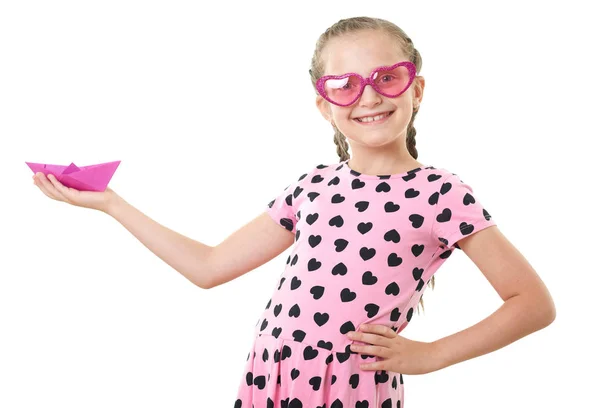 Hezká holčička s papíru loď studiový portrét, oblečená v růžovém s srdce tvary, bílým pozadím — Stock fotografie