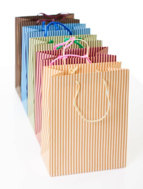 üst üste nesne üzerinde beyaz izole düzenlenmiş renkli çizgili alışveriş torbaları