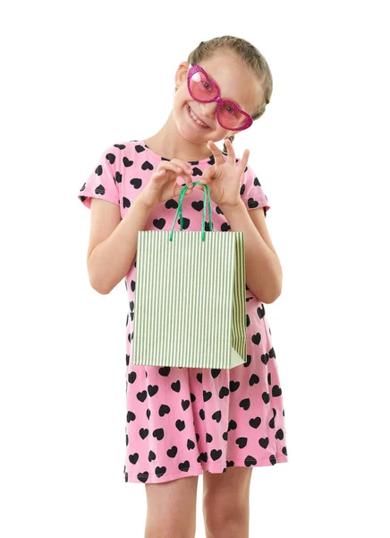 Pretty little girl with shopping bag, studio portrait, dressed in pink with heart shapes, white background — Stock Photo, Image