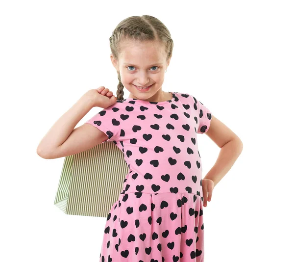 Όμορφο κοριτσάκι με τσάντα αγορών, πορτραίτο στούντιο, ντυμένη στα ροζ με καρδιά σχήματα, λευκό φόντο — Φωτογραφία Αρχείου
