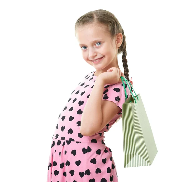 Pretty little girl with shopping bag, studio portrait, dressed in pink with heart shapes, white background — Stock Photo, Image