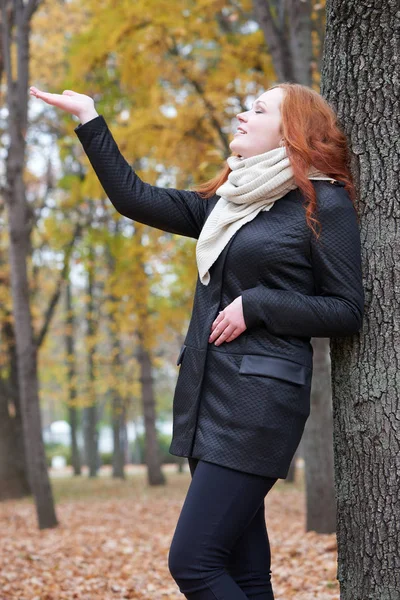 Young woman stand near tree in autumn park, yellow leaves — Stock Photo, Image