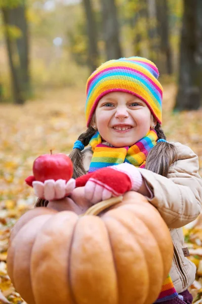 Çocuk yemek elma ve kabak ormanda, sit sonbahar üzerinde arka plan, Sonbahar sezonu bırakır.