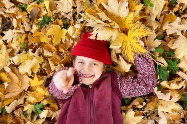 Kız yalan üzerinde sarı yapraklar arka plan üzerinde sonbahar ormandaki geri