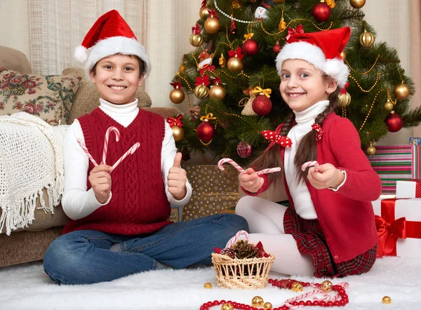Niño en sombrero de sanata jugando, decoración de Navidad en casa, emoción feliz, concepto de vacaciones de invierno Imagen De Stock