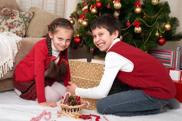 Eğleniyor ve oynarken, hediyeler, Noel dekorasyonu evde, mutlu duygu, kış tatil kavramı paylaşımı santa şapkalı çocuk