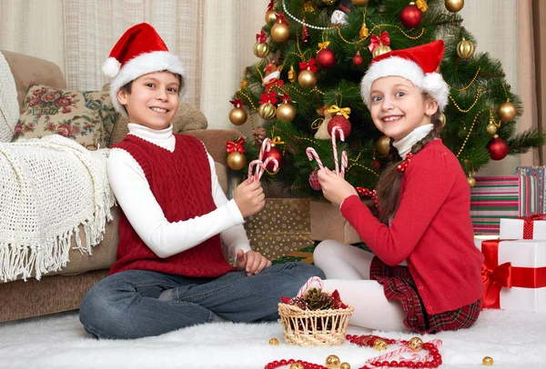 Dziecko w santa hat zabawy i gry, świąteczne dekoracje w domu, szczęśliwy emocji, zimowe wakacje koncepcja — Zdjęcie stockowe
