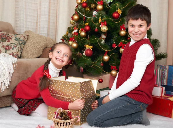 Дитина в капелюсі Санта розважається і грає, ділиться подарунками, різдвяні прикраси вдома, щасливі емоції, концепція зимового свята — стокове фото