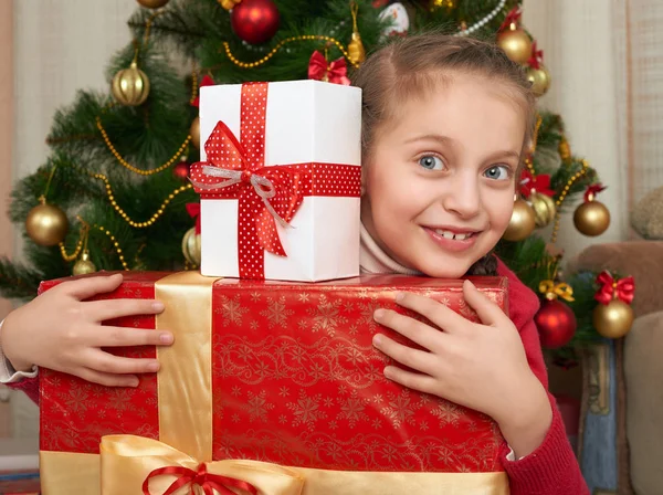 クリスマス ツリー、幸せな休日とクリスマスのお祝いのギフト ボックスを持つ少女 — ストック写真